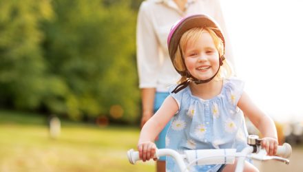 Smiling baby girl riding bicycle